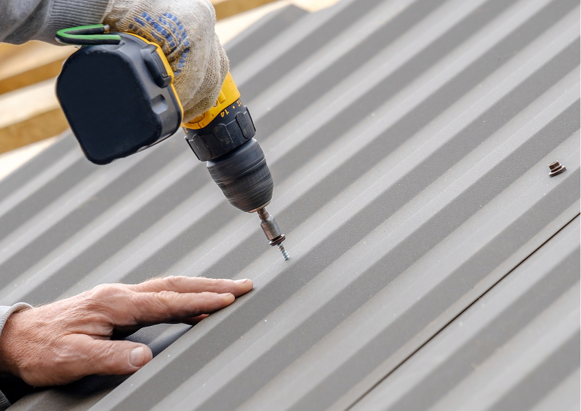 worker using power tool on roof